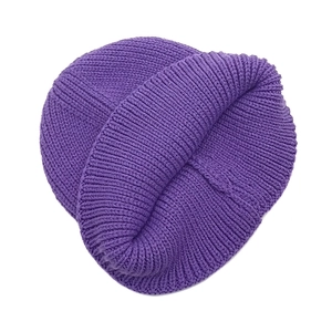 Macro view of thick ribbed knit texture on deep purple winter beanie cap