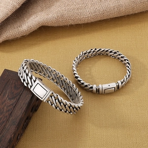 Macro view of retro antique silver woven square titanium steel bracelets on wood