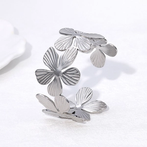 Détail macro d'un bracelet ouvert floral argenté avec des pétales texturés et finition métal