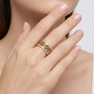 Détail d'une bague à chaîne cubaine plaquée or sertie de zircons portée par un mannequin