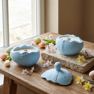 Detailed view of light blue ceramic egg-shaped candle with wooden wick for Easter decor