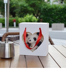 White gift box with heart window containing a panda plush toy and silver heart necklace