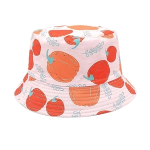 Détail d'un chapeau bob enfant rose avec motifs citrouilles oranges et feuilles