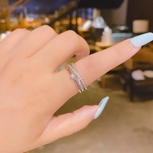Close-up of double-layer crisscross silver ring with sparkling cubic zirconia on a finger