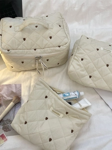 Gestepptes creme-kosmetiktaschen-set mit braunem herzmuster für die reiseorganisation
