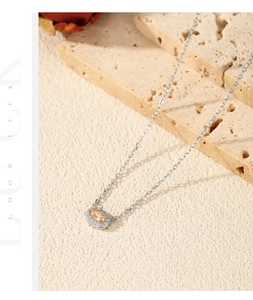 Macro shot of silver necklace with oval orange gemstone pendant and zircon accents