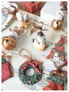 Detailed view of festive resin Christmas ornaments with bell and tree on vintage book background