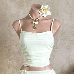Detail view of light beige ruched bikini top with delicate thin shoulder straps