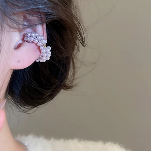 Detailed view of elegant pearl ear cuff on a model, showing luxury beaded flower design