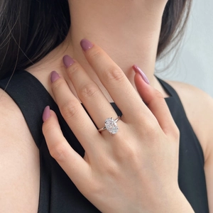 Detailed close-up of a pear-shaped oval cut zircon ring on a finger with silver finish