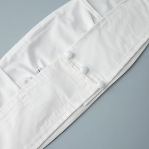 Détail de la robe en coton avec boutons blancs et étiquette de taille S cousue