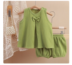 Détail d'un ensemble bébé en gaze de coton vert avec haut à nœud et short bouffant