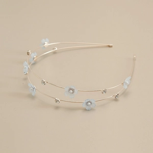 Detail of a double-layered golden headband featuring light blue flowers and faux pearls