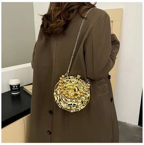 Detail of a golden rose-shaped evening clutch bag with metal chain strap on a brown coat