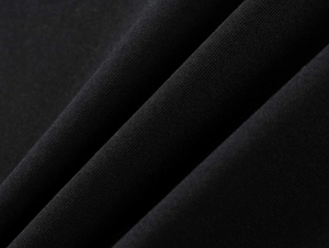 Close-up of black breathable athletic knit fabric with soft texture and refined drape