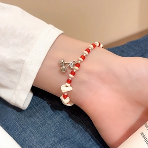 Detailed view of red and white ceramic crystal beads with cherry pendant on wrist