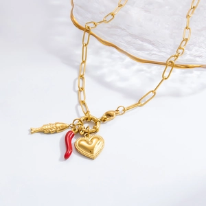 Detailed close-up of gold chain necklace with heart, fish, and red chili charms