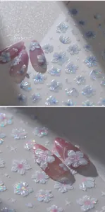 Macro detail of 3D iridescent cherry blossom nail art stickers on purple fake nails