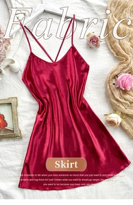 Detail view of burgundy satin slip dress with thin cross-back straps on white hanger