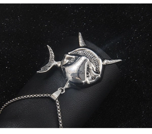 Detailed view of silver shark head pendant with box chain on black display stand