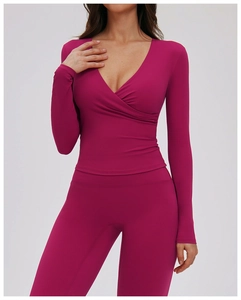 Detail of berry red V-neck wrap top and high-waist yoga pants in elastic fabric