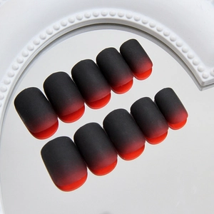Matte black and red gradient press-on nails set with 24 pieces on a mirror surface