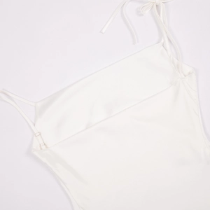 Détail des bretelles réglables et du satin blanc soyeux d'une robe à col bénitier