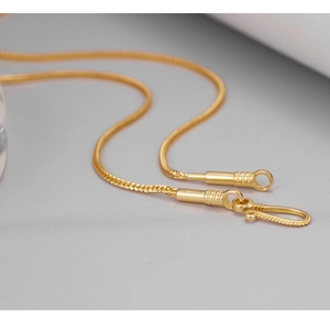 Macro close-up of a gold-colored snake chain featuring a detailed S-hook clasp and weave