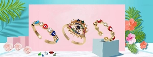 Detailed view of three gold open rings with evil eye patterns and colorful zircons