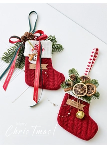 Detalle de calcetines de Navidad rojos tejidos con piñas, bellotas y etiquetas de madera