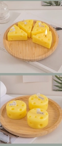Close-up of yellow cheese-shaped scented candles in block and cylinder forms on wood