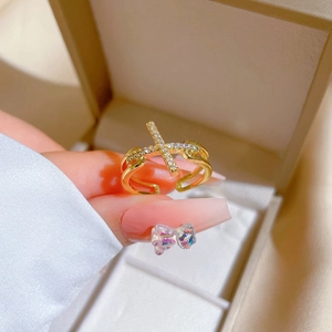 Elegant gold plated cross ring with micro-set crystals shown on a model's finger