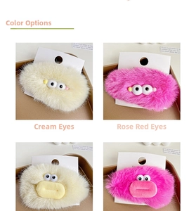 Close-up of plush hair clips with cartoon monster eyes in yellow and rose pink