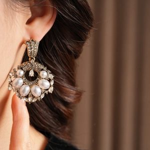 Détails de boucles d'oreilles vintage en or avec perles élégantes et strass brillants