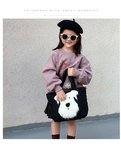 Detail of black quilted children crossbody bag featuring a cute white puppy embroidery