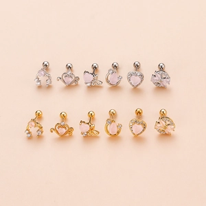 Détails d'un lot de boucles d'oreilles cœur en or et argent avec zircon rose sur fond pêche