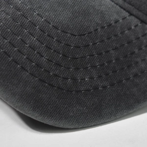 Macro shot of dark grey washed baseball cap brim with dense six-row reinforced stitching