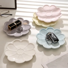 Top view of five colorful ceramic flower-shaped jewelry trays with beaded edge details