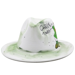 Détail d'un chapeau de jazz blanc en feutre avec graffiti vert et dessin de lutin