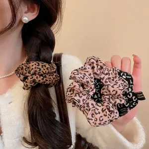 Three-piece leopard print scrunchie set in brown, pink, and grey chiffon fabric
