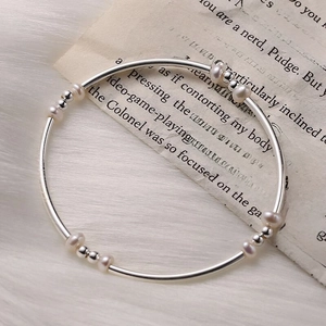 Elegant S925 sterling silver freshwater pearl bracelet on vintage book and faux fur background