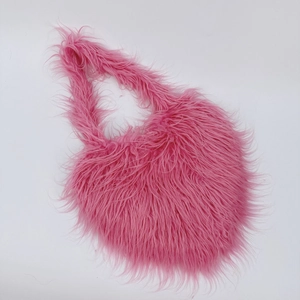 Detailed macro view of soft pink faux fur texture on a heart-shaped luxury handbag