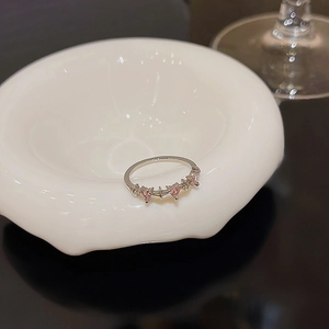Detailed view of silver band ring featuring three pink heart-shaped zircon stones