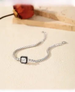 Dettaglio di un bracciale tennis in argento S925 con pietra quadrata e accenti neri