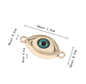 Detail view of evil eye metal charm pendant with dimensions 1.5cm by 0.7cm on white background