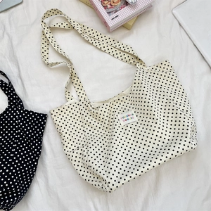Close-up of lightweight polka dot canvas tote bags with colorful logo patch and soft texture