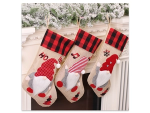 Close-up of three burlap Christmas stockings with gnome appliques on a white fireplace