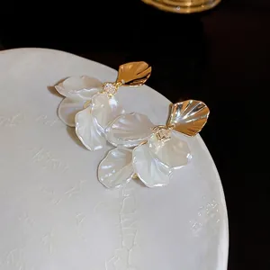 Macro de boucles d'oreilles fleur en perles avec pétales dorés et zircons brillants