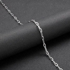 Detailed close-up of polished silver stainless steel rectangular chain links on textured surface