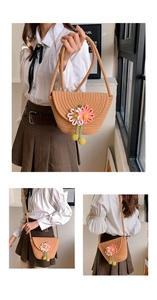 Detail of straw woven bucket bag with knitted daisies and long shoulder strap